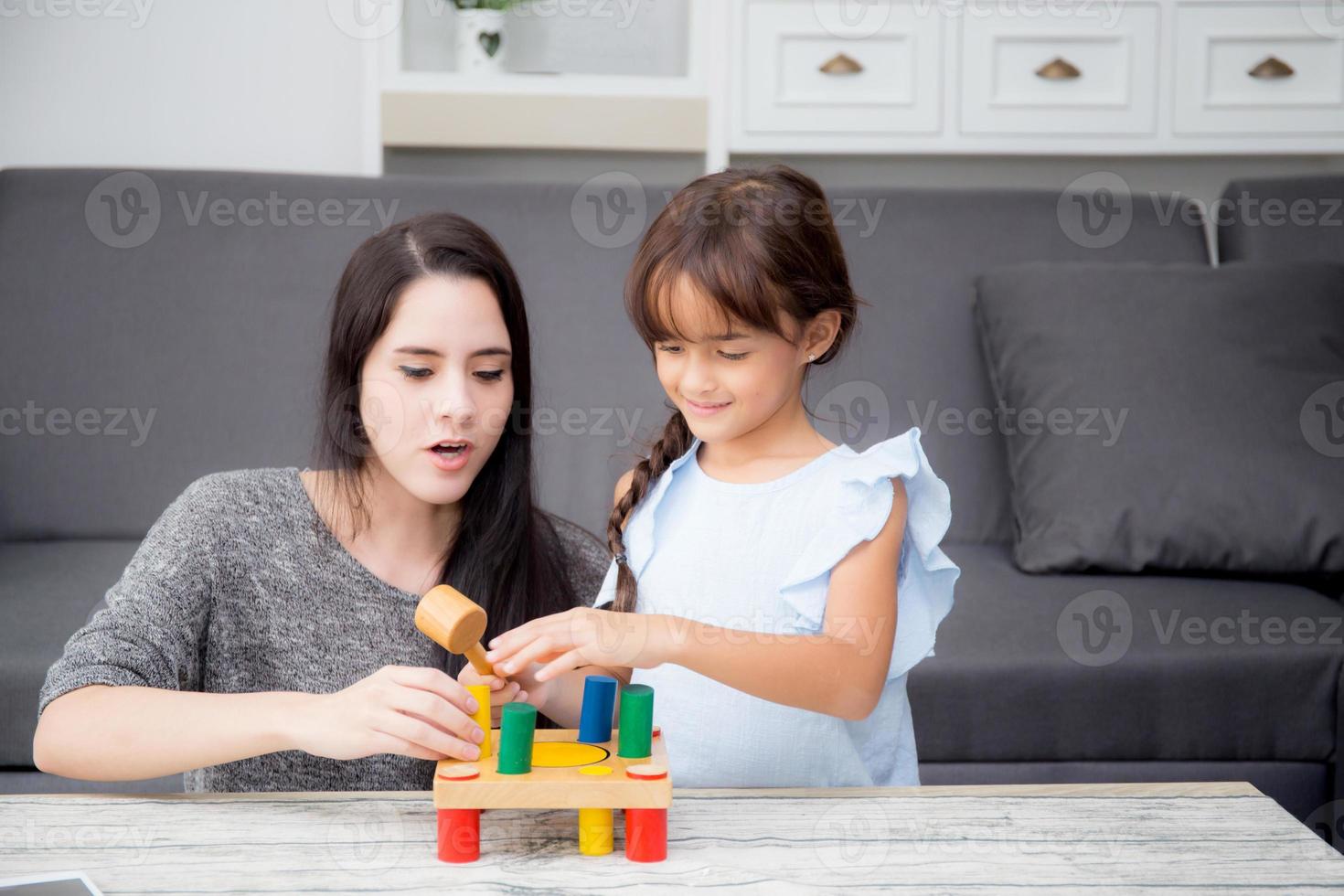 Mother and child play toy together on the living room at home, kid with developing learning for education with activity with family, mom teaching daughter with fun and skill in pastime. photo