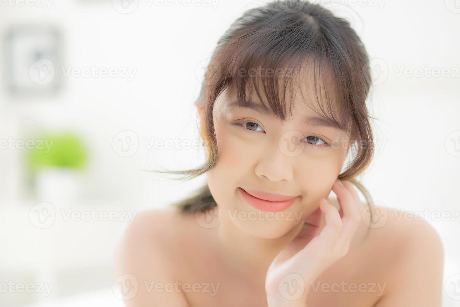 hermoso retrato joven mujer asiática acostada y sonriendo mientras se despierta con el amanecer en la mañana, belleza linda chica feliz y alegre descansando en la cama en el dormitorio, estilo de vida y concepto de relajación. foto