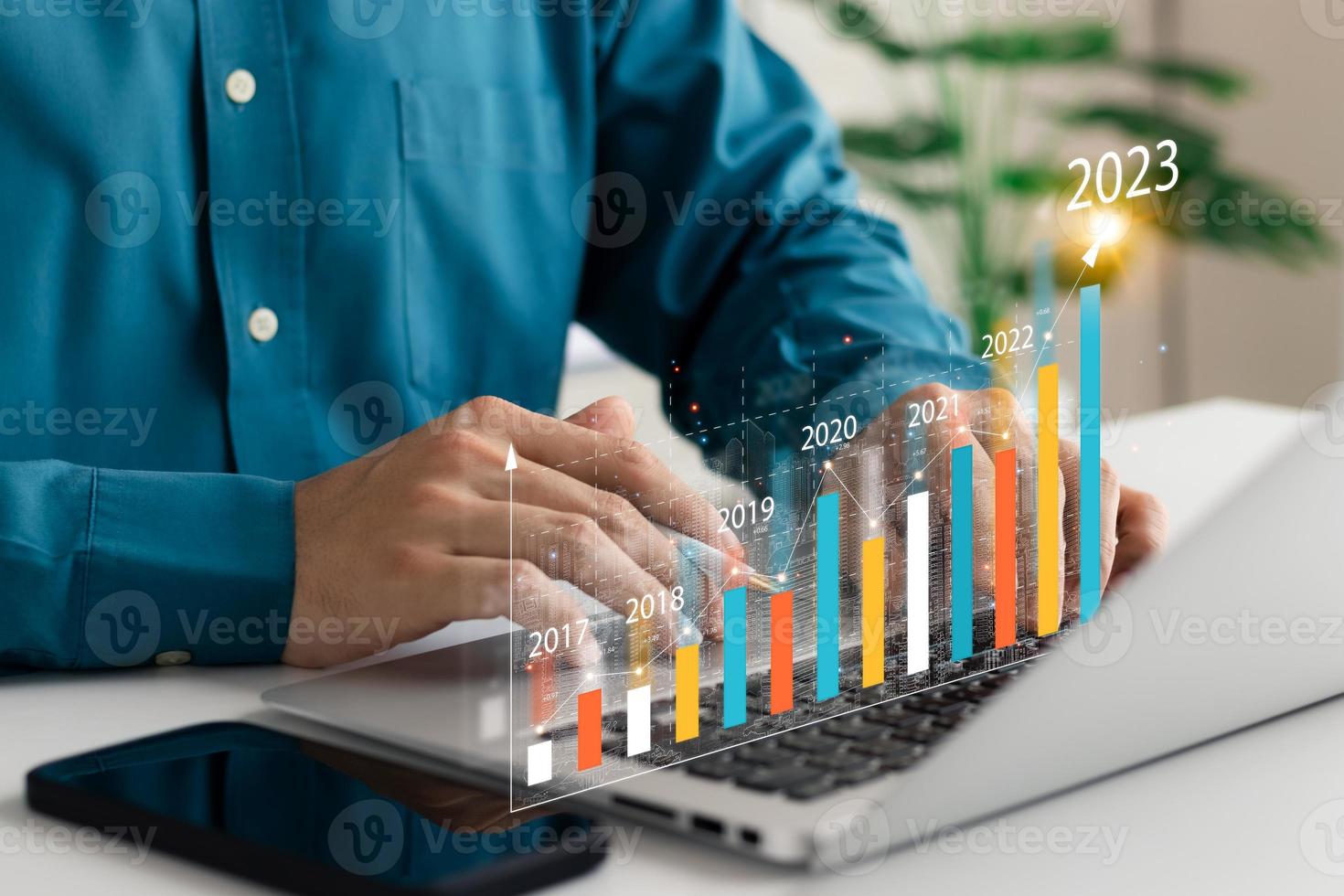 Businessman analyzes profitability of working companies with digital augmented reality graphics, positive indicators in 2023, businessman calculates financial data for long-term investments. photo