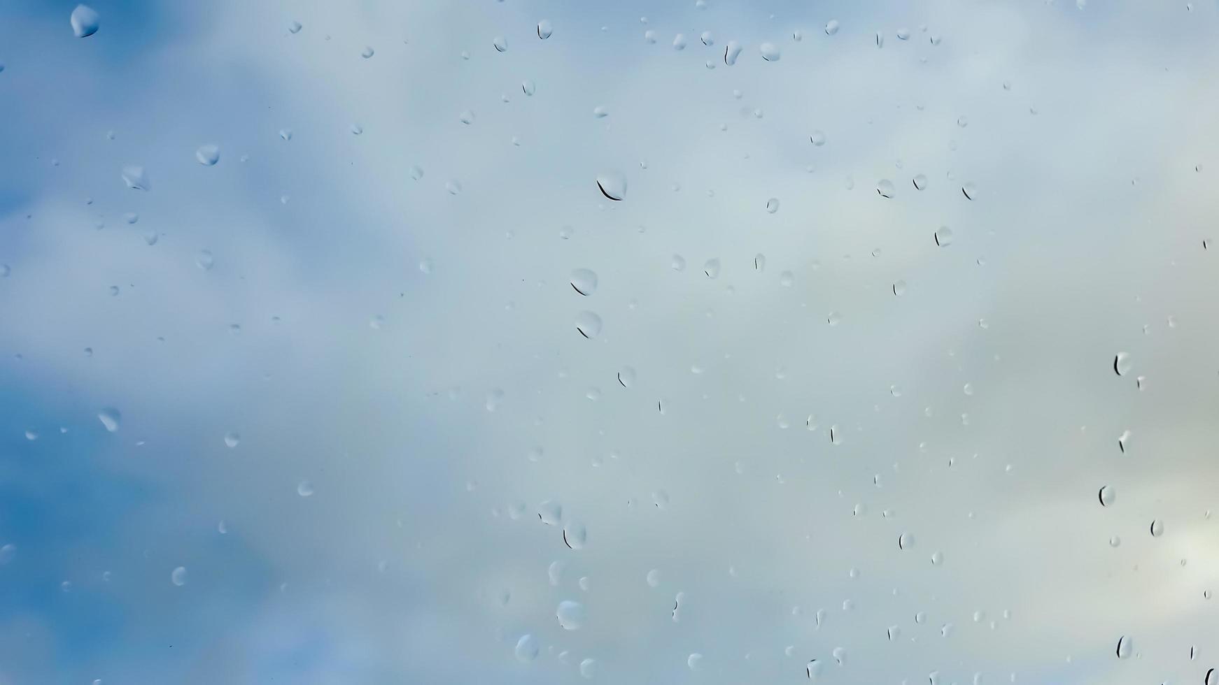 Rain drops running down a window in a close up view. photo