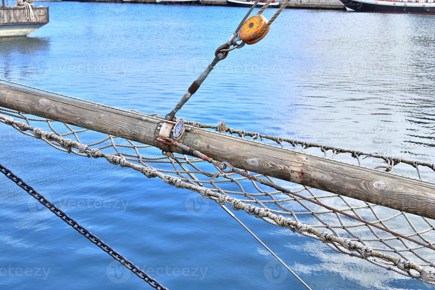Sailing ship mast against the blue sky on some sailing boats with rigging details. photo