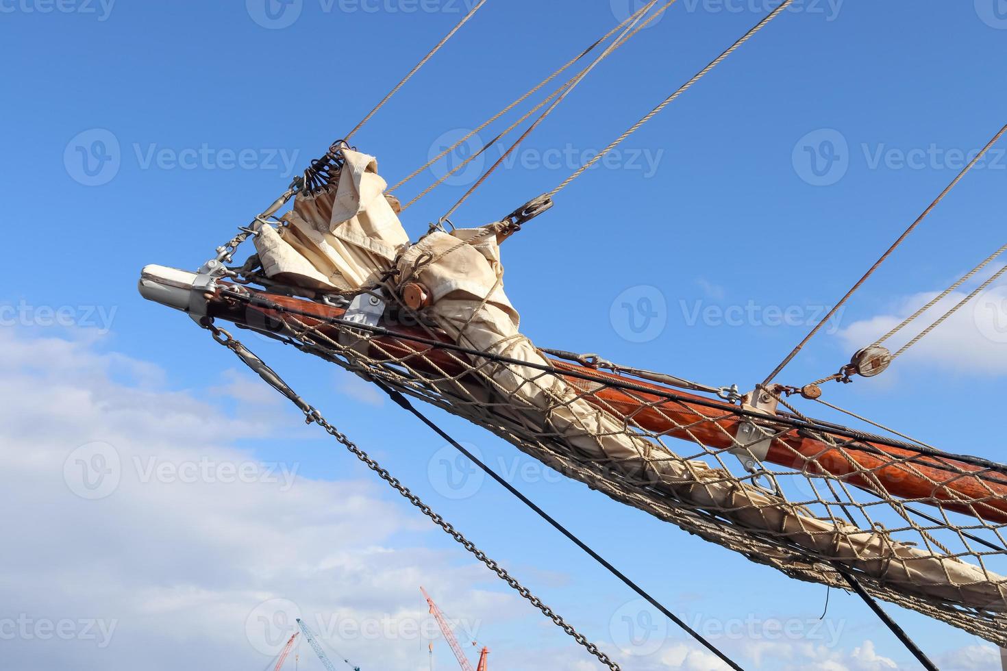 Sailing ship mast against the blue sky on some sailing boats with rigging details. photo
