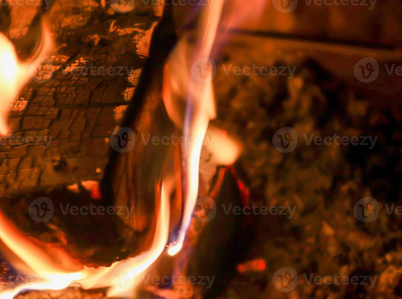 Beautiful red and orange hot burning fire in a fireplace photo