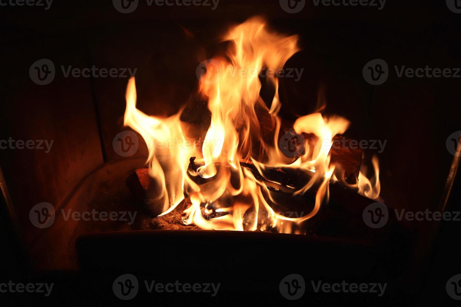 hermoso fuego ardiente rojo y naranja en una chimenea foto