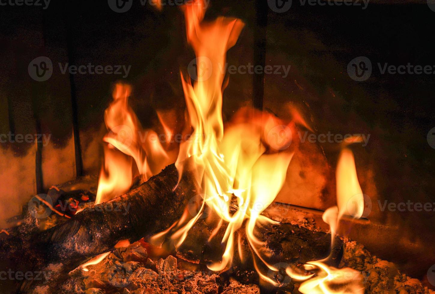 hermoso fuego ardiente rojo y naranja en una chimenea foto