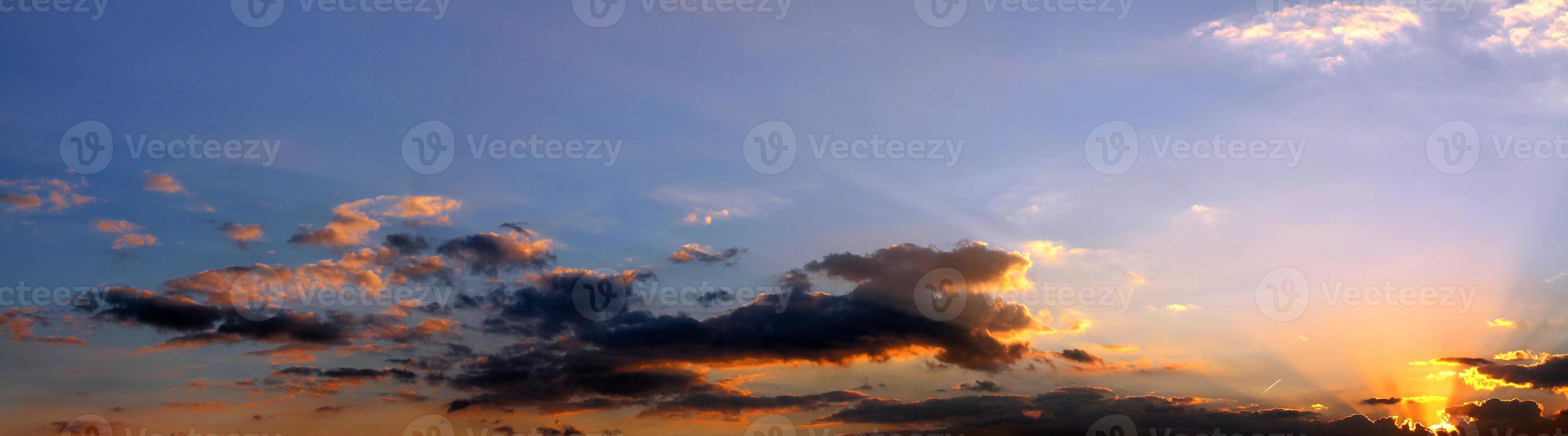 Beautiful high resolution panorama of orange and red sunset clouds in the evening sky photo
