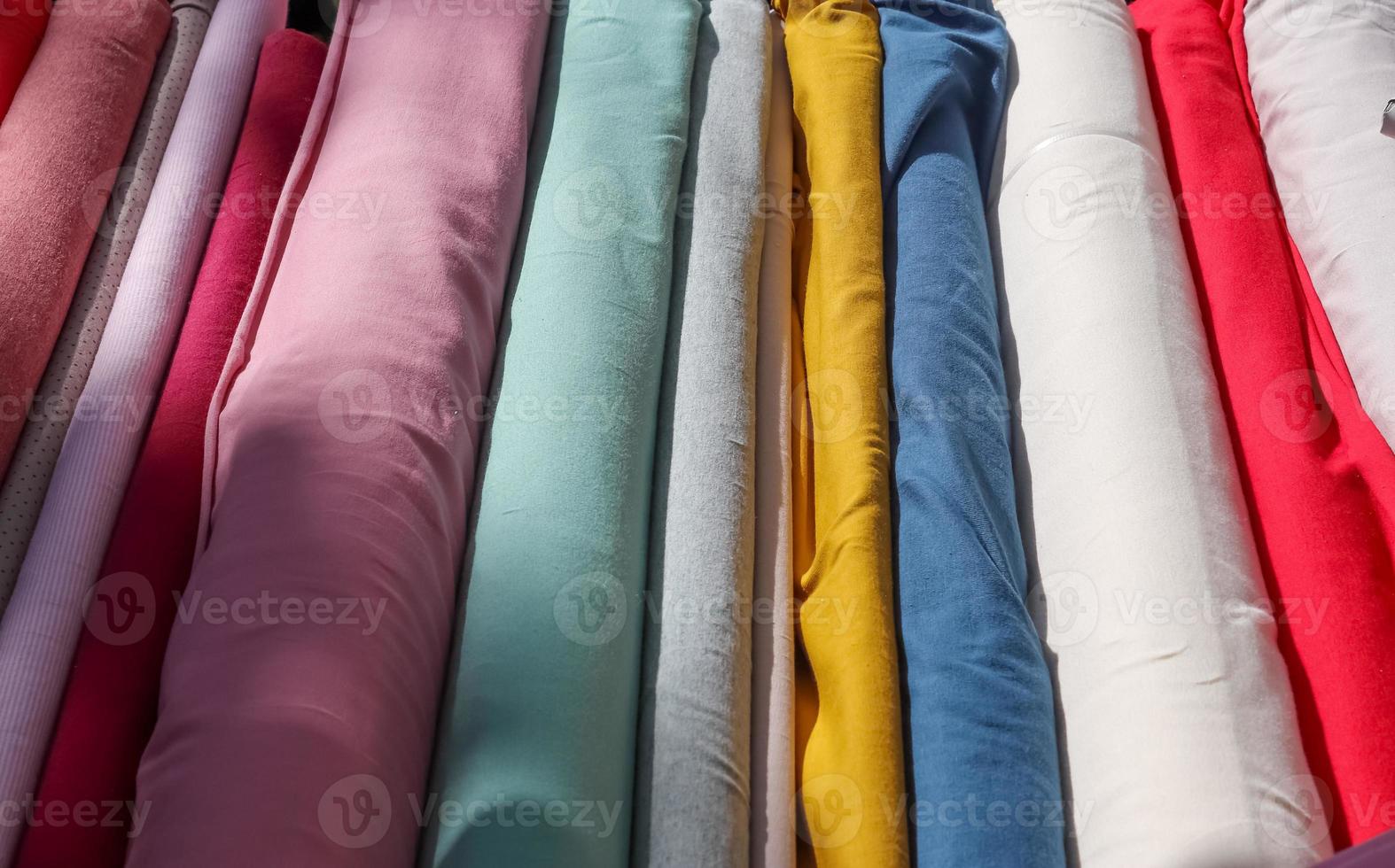 Detailed close up view on samples of cloth and fabrics in different colors found at a fabrics market photo