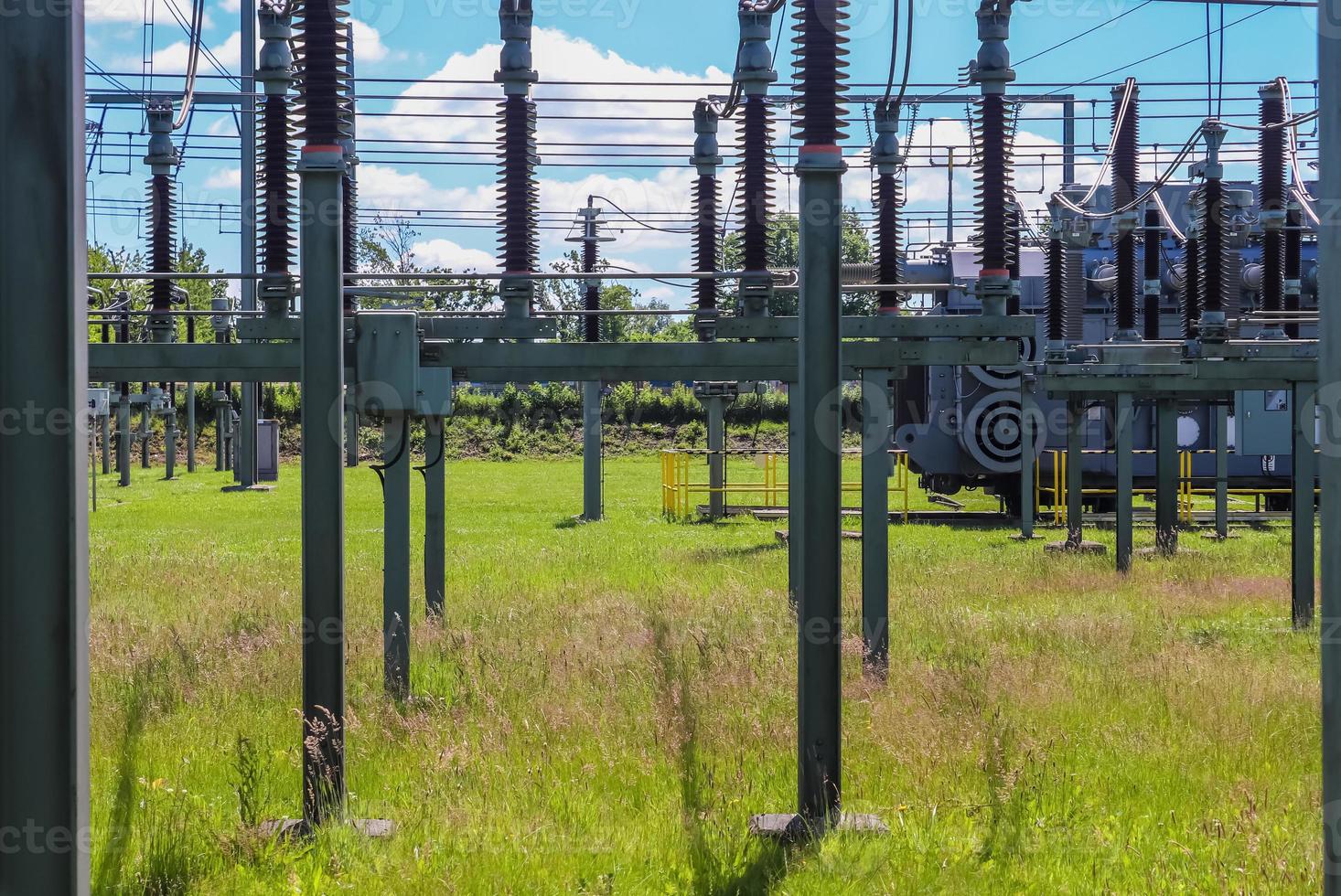 Electrical Transformer. Distribution of electric energy at a big substation with lots power lines on a sunny day photo