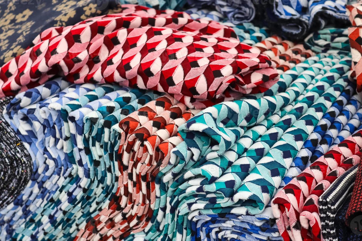 Detailed close up view on samples of cloth and fabrics in different colors found at a fabrics market photo