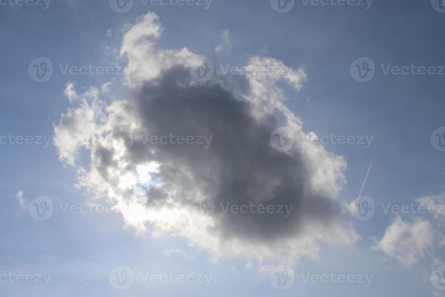 Beautiful view at sunbeams with some lens flares and clouds in a blue sky photo