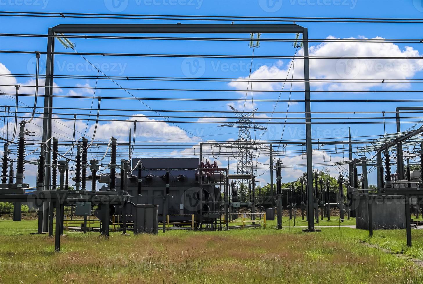 Electrical Transformer. Distribution of electric energy at a big substation with lots power lines on a sunny day photo