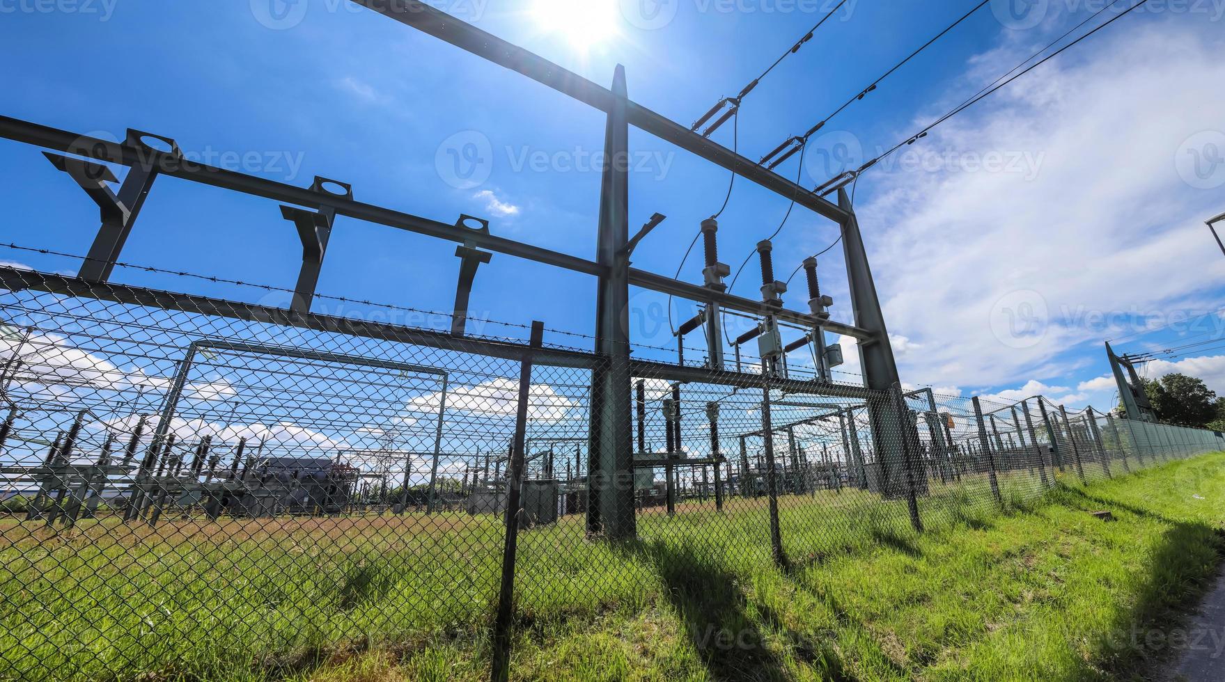 Electrical Transformer. Distribution of electric energy at a big substation with lots power lines on a sunny day photo
