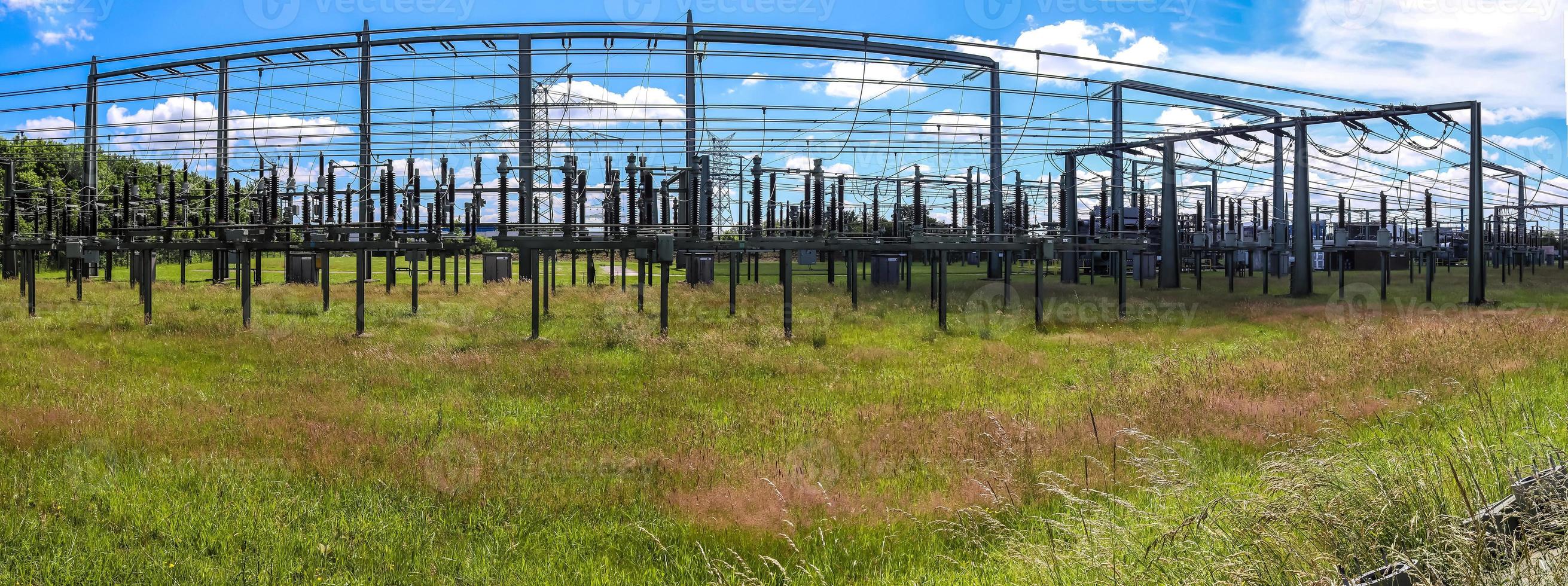 Electrical Transformer. Distribution of electric energy at a big substation with lots power lines on a sunny day photo