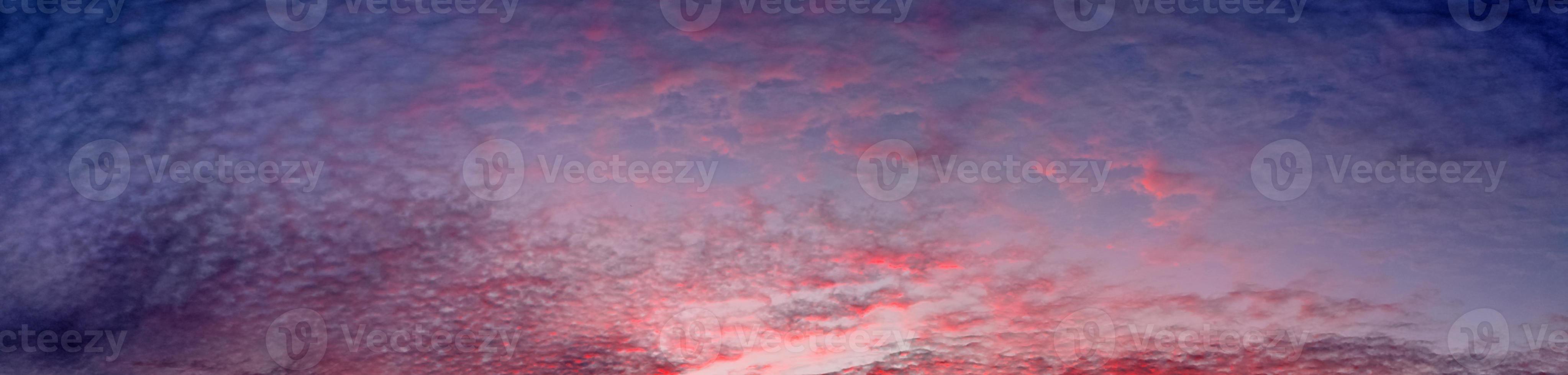 Beautiful high resolution panorama of orange and red sunset clouds in the evening sky photo