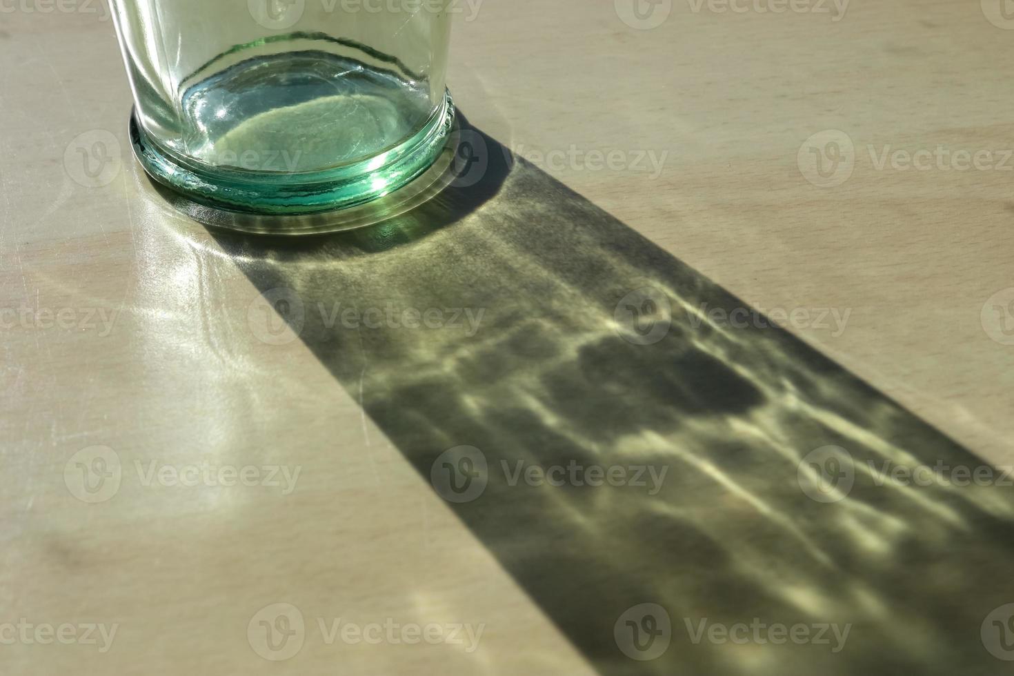 Sunlight shining through a drinking glas showing caustic light effects. photo