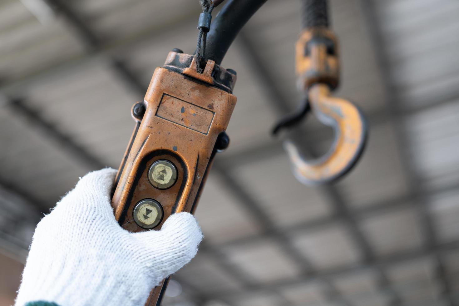 botones de control industriales. mano que sostiene el mando a distancia de las grúas aéreas. interruptor del controlador hidráulico arriba abajo. interruptor de botón remoto eléctrico de elevación o grúa para control de dirección. foto