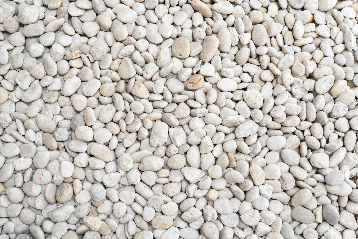 White pebble stone texture on the ground. The pebbles closely stone texture features photo