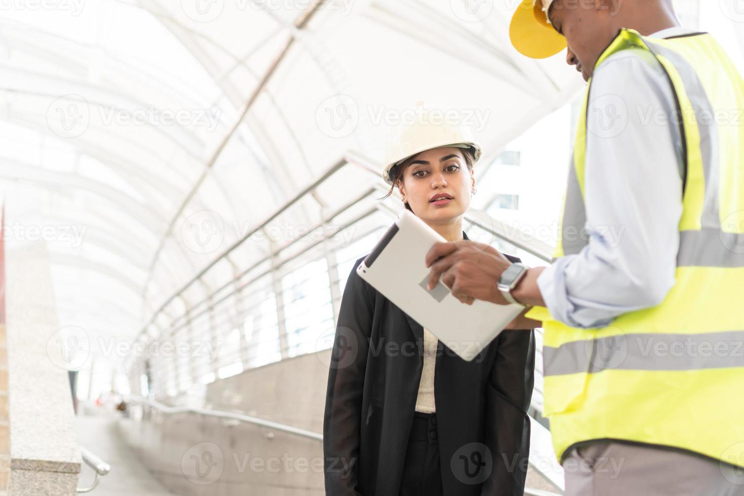 Engineer Manager , Businessman and woman secretary Meeting working Team building using tablet. Engineers are talking about plan to work. Engineer and architect team checking construction photo