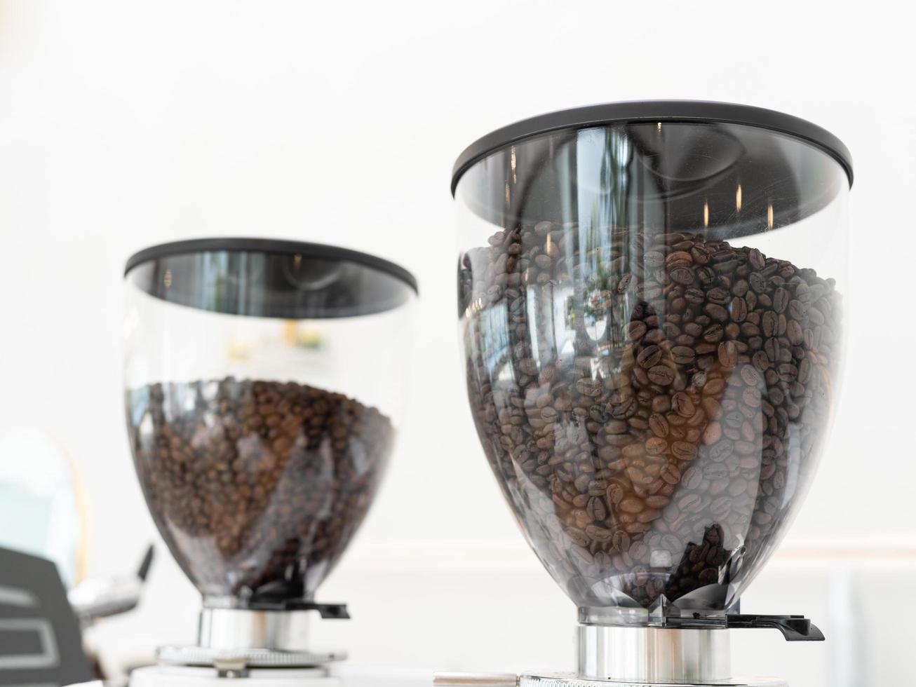 Coffee beans in machine. Close up of coffee beans in a grinder photo