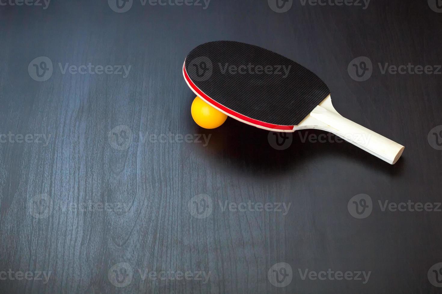 tenis de mesa o raqueta de ping pong y pelota en un fondo negro foto