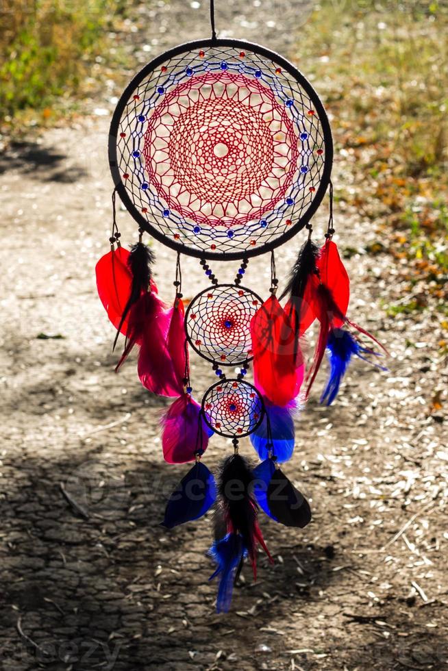 atrapasueños hecho a mano con hilos de plumas y cuerda de cuentas colgando foto