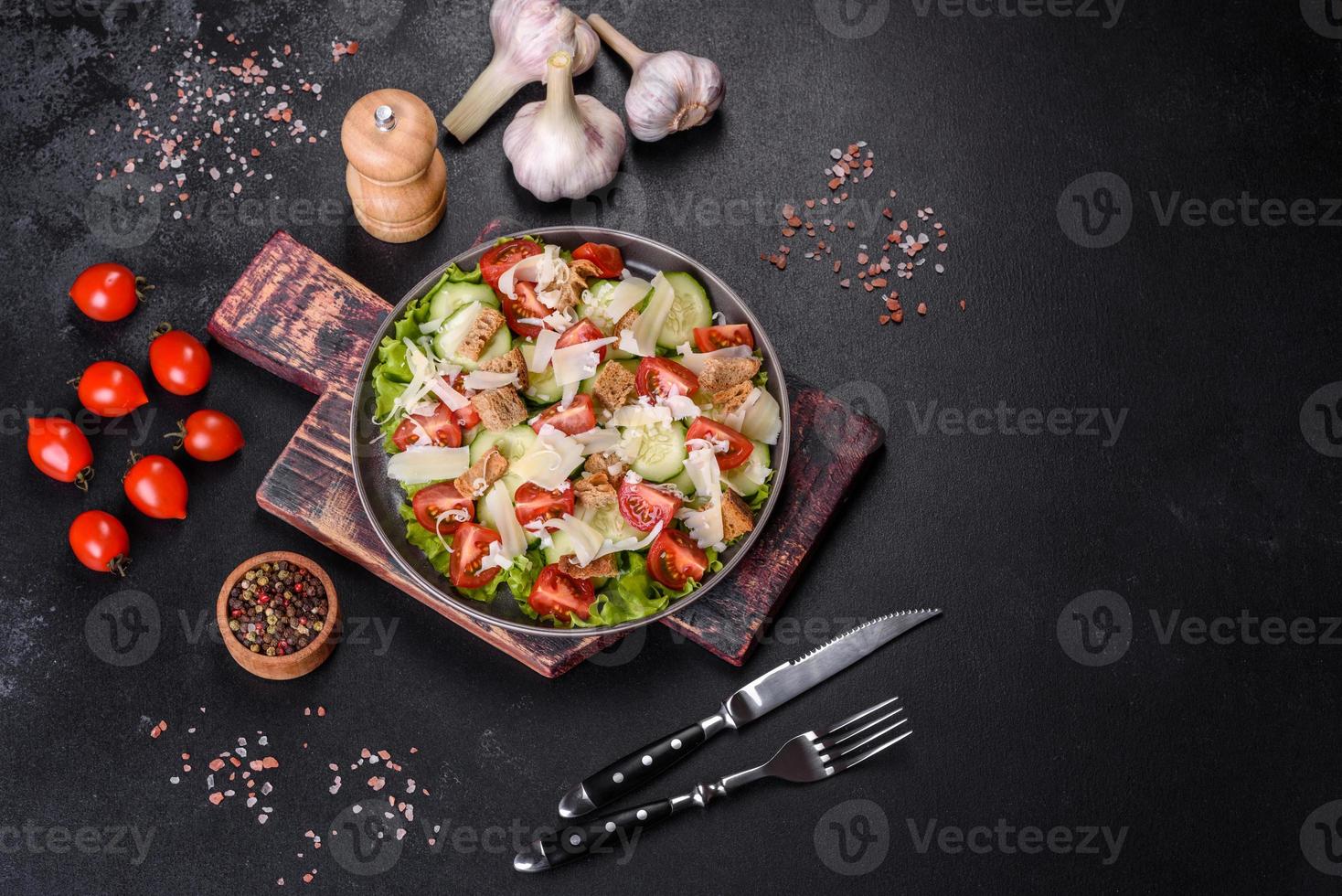 deliciosa ensalada de verduras frescas de primavera con tomates cherry, pepino, pan rallado y queso parmesano foto