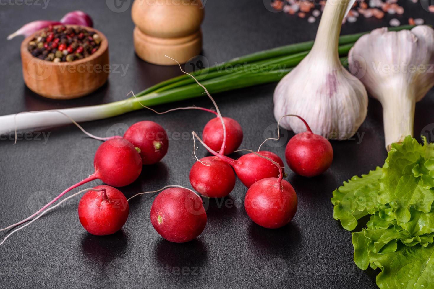 delicioso rábano rojo fresco como ingrediente para hacer ensalada de primavera en tabla de cortar de madera foto