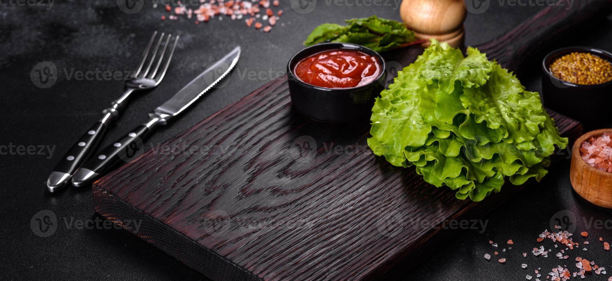 A wooden cutting board with a kitchen knife with spices and herbs photo