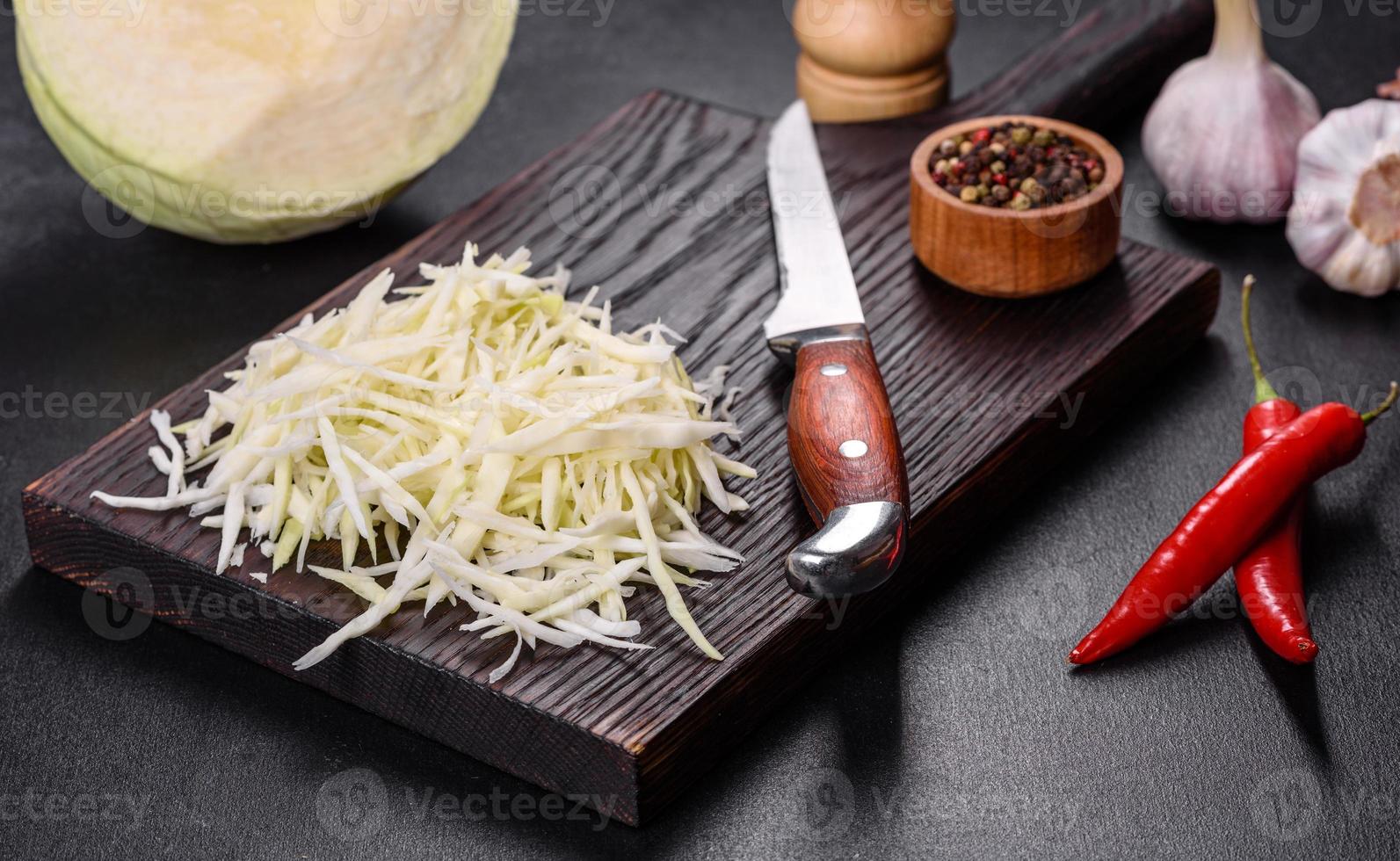 Part of a cabbage head and chopped cabbage salad on wooden cutting board photo