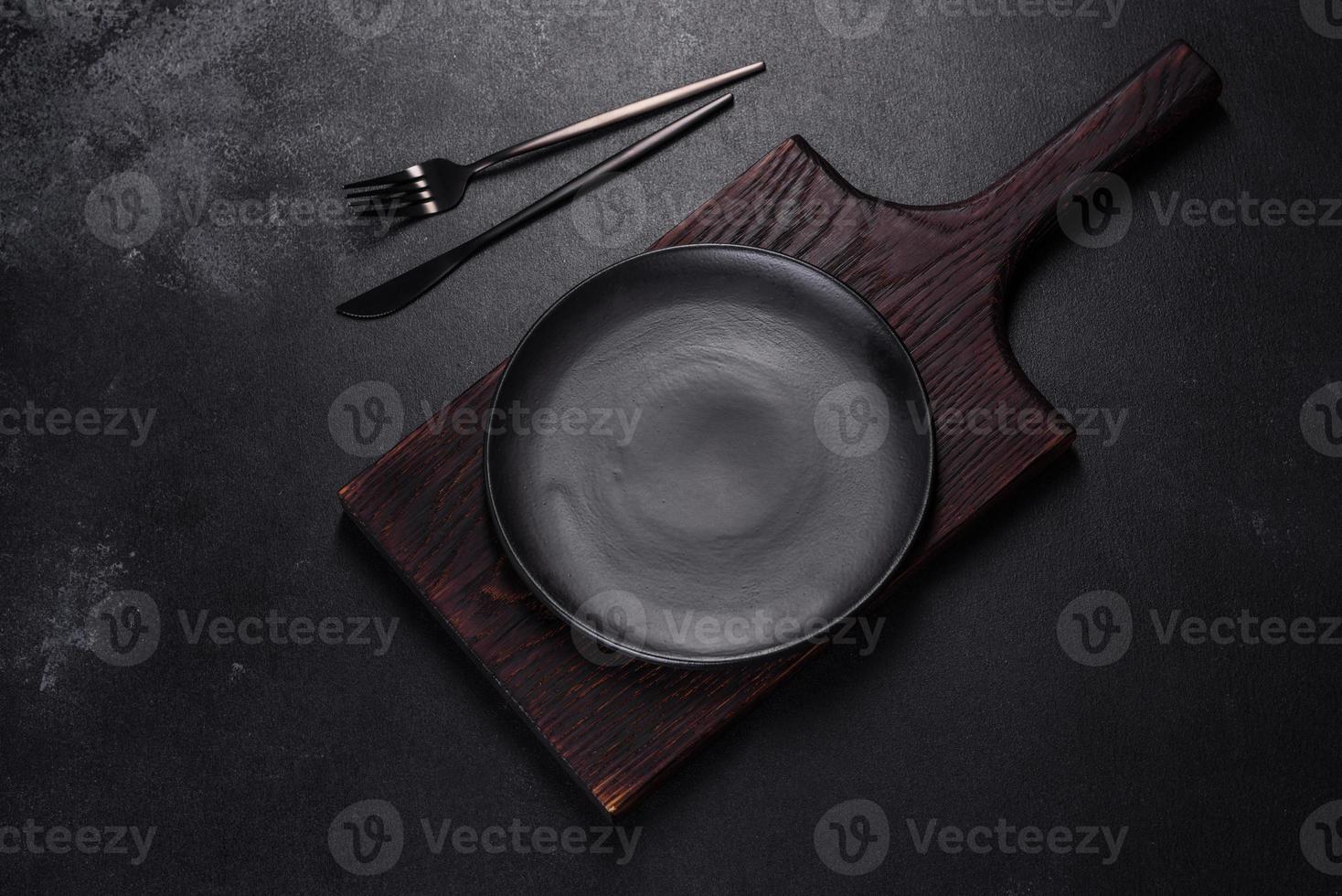 An empty plate with a knife, fork or spoon with a wooden cutting board photo