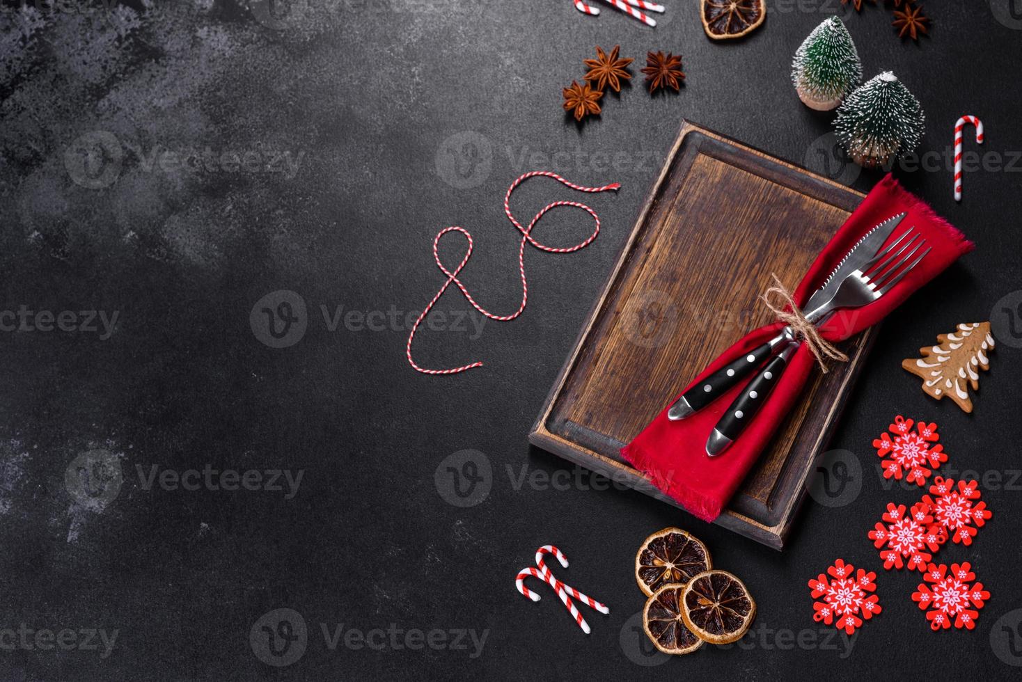 Christmas table setting with empty black ceramic plate, fir tree and black accessories photo