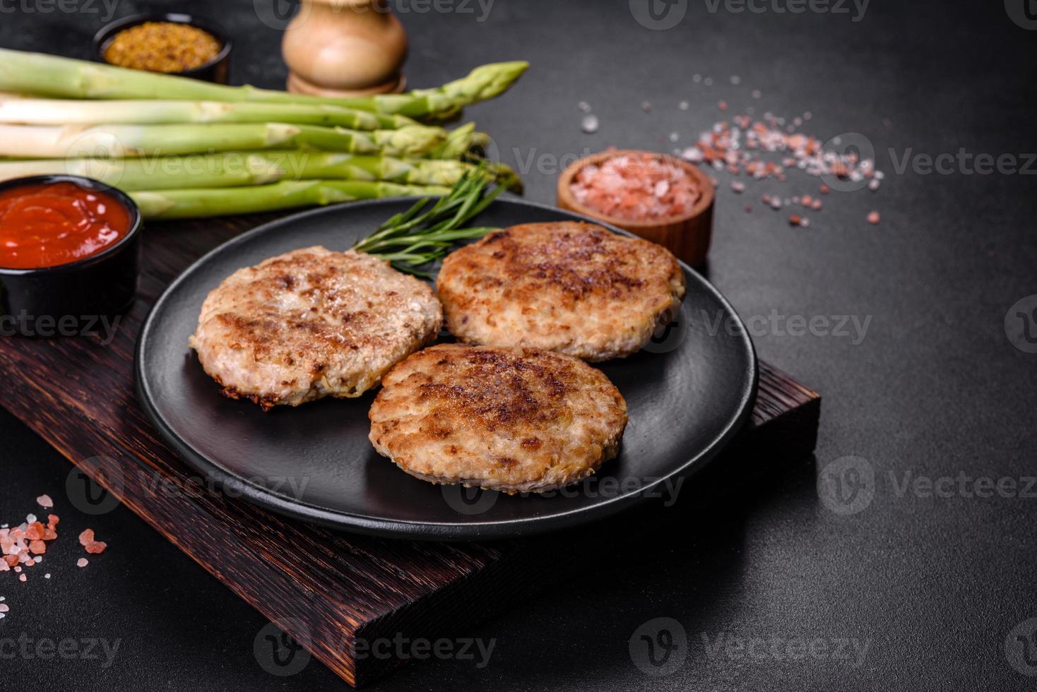 Flat lay composition with grilled meat cutlets for burger on black concrete table photo