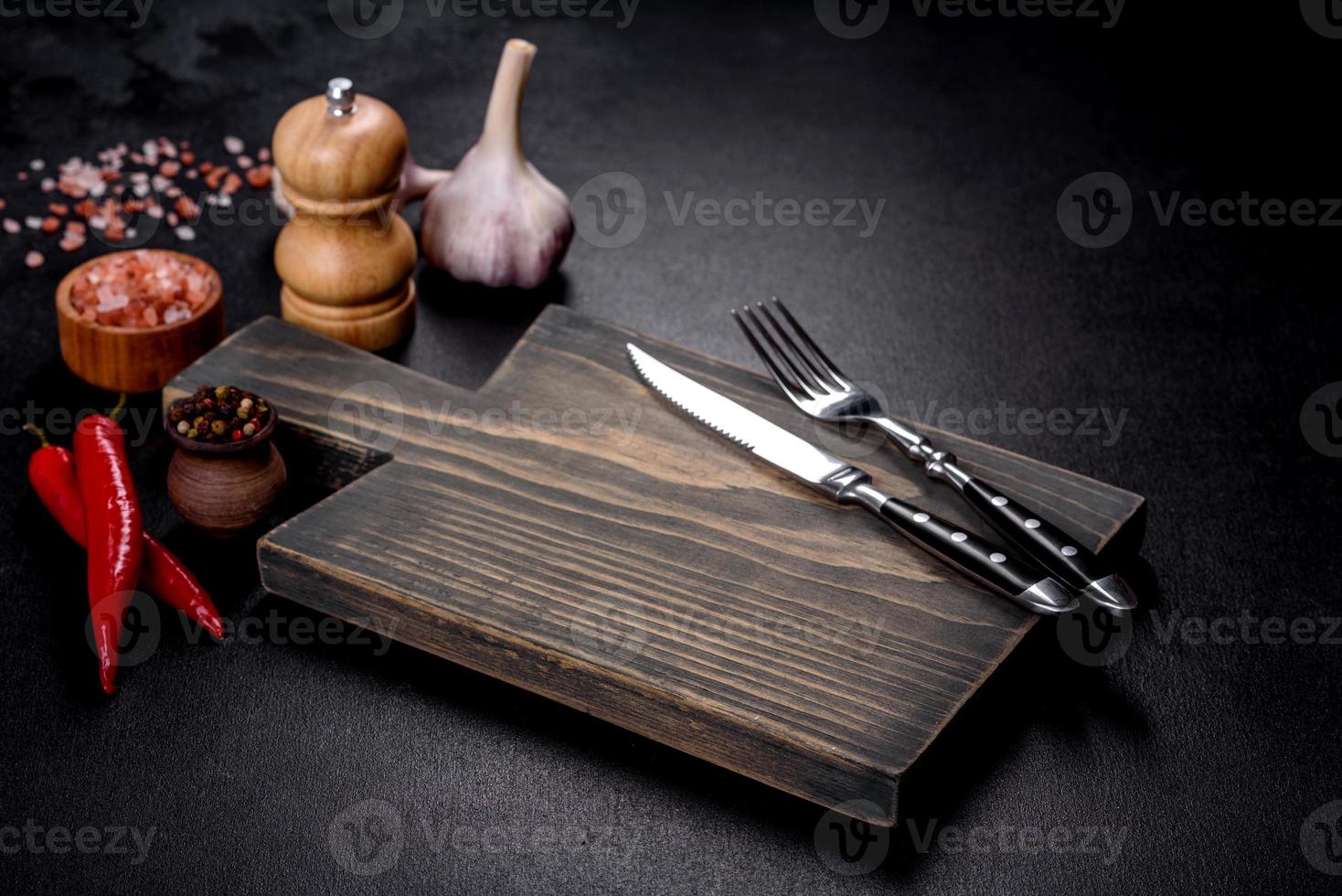 An empty plate with a knife, fork or spoon with a wooden cutting board photo