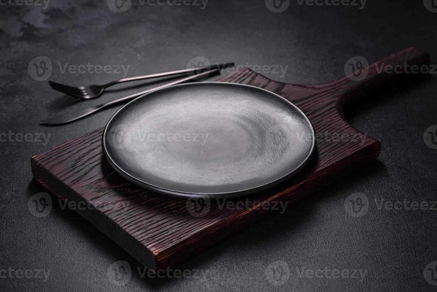 un plato vacío con un cuchillo, tenedor o cuchara con una tabla de cortar de madera foto
