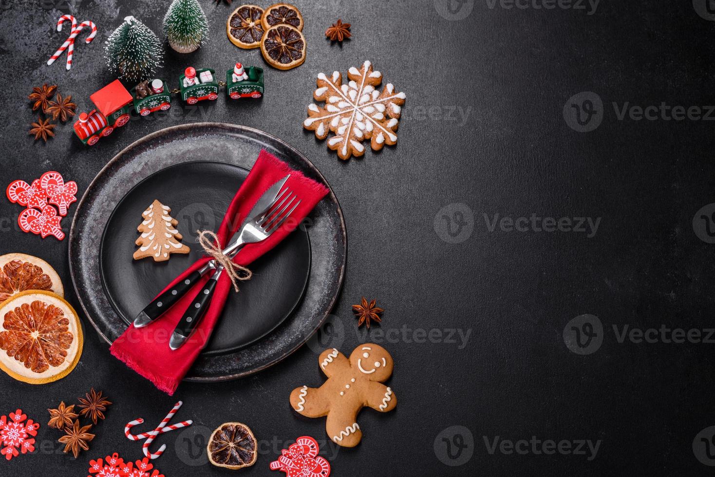 Christmas table setting with empty black ceramic plate, fir tree and black accessories photo