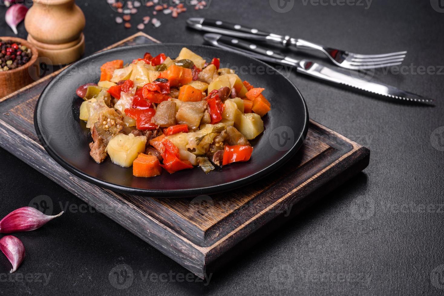 estofado de verduras o ratatouille con berenjenas, tomates, pimientos dulces y picantes, cebollas, zanahorias y especias en un plato foto