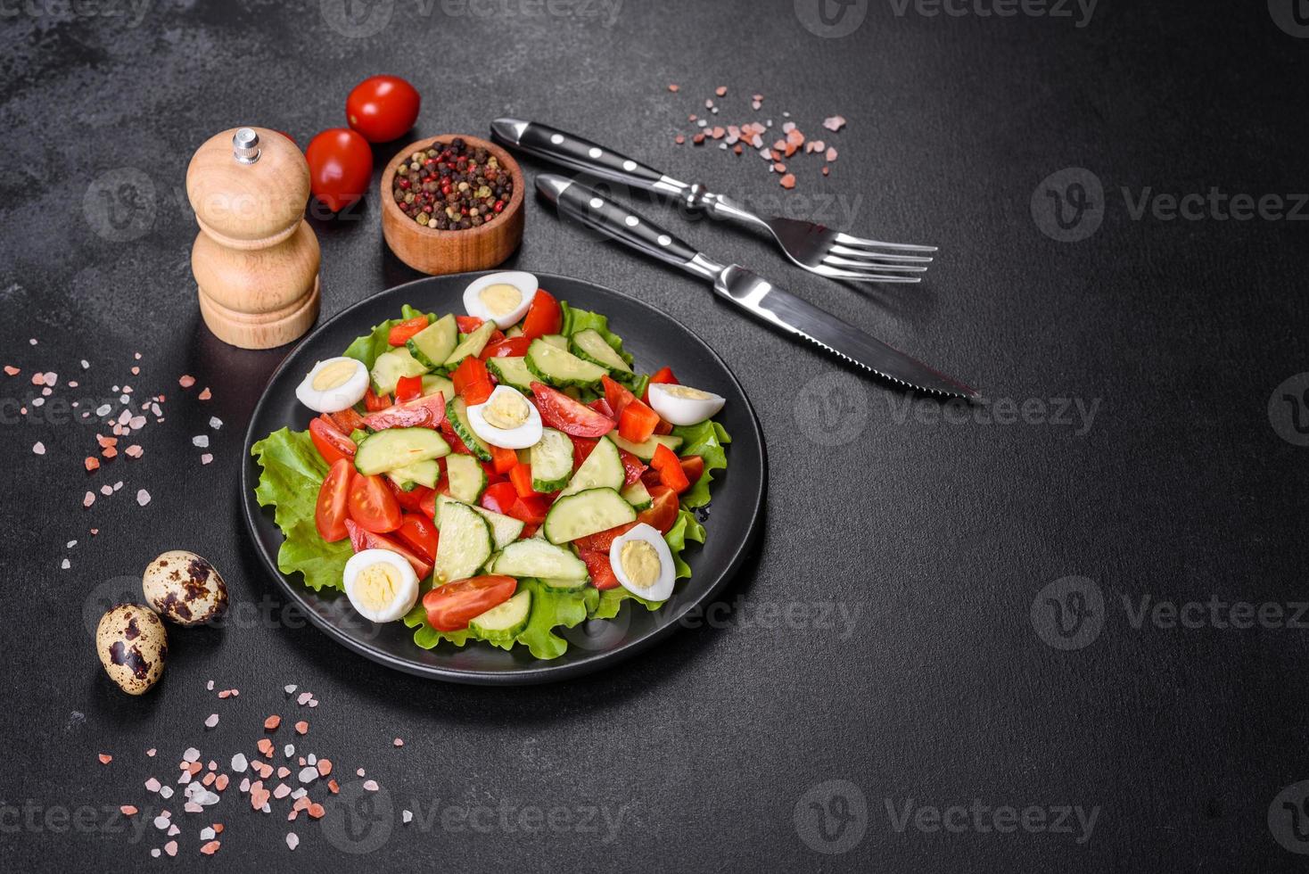 Ensalada de lechuga, pepino, espinacas, tomate y huevos de codorniz con hierbas y limón foto