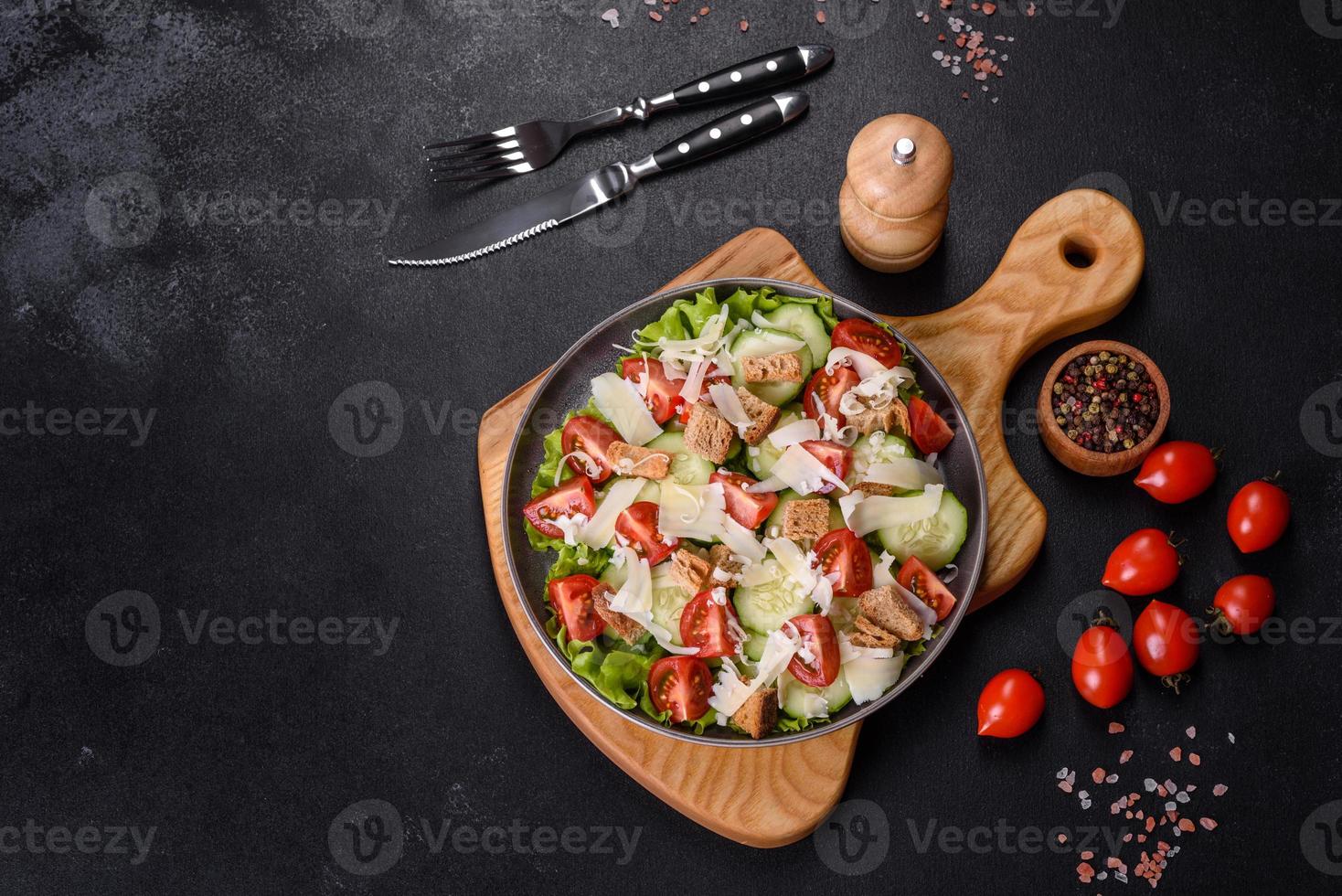 deliciosa ensalada de verduras frescas de primavera con tomates cherry, pepino, pan rallado y queso parmesano foto