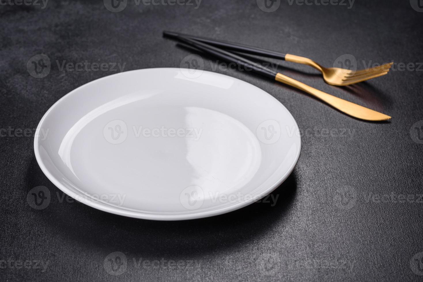 White plate on a black background. Flat lay, top view, copy space photo