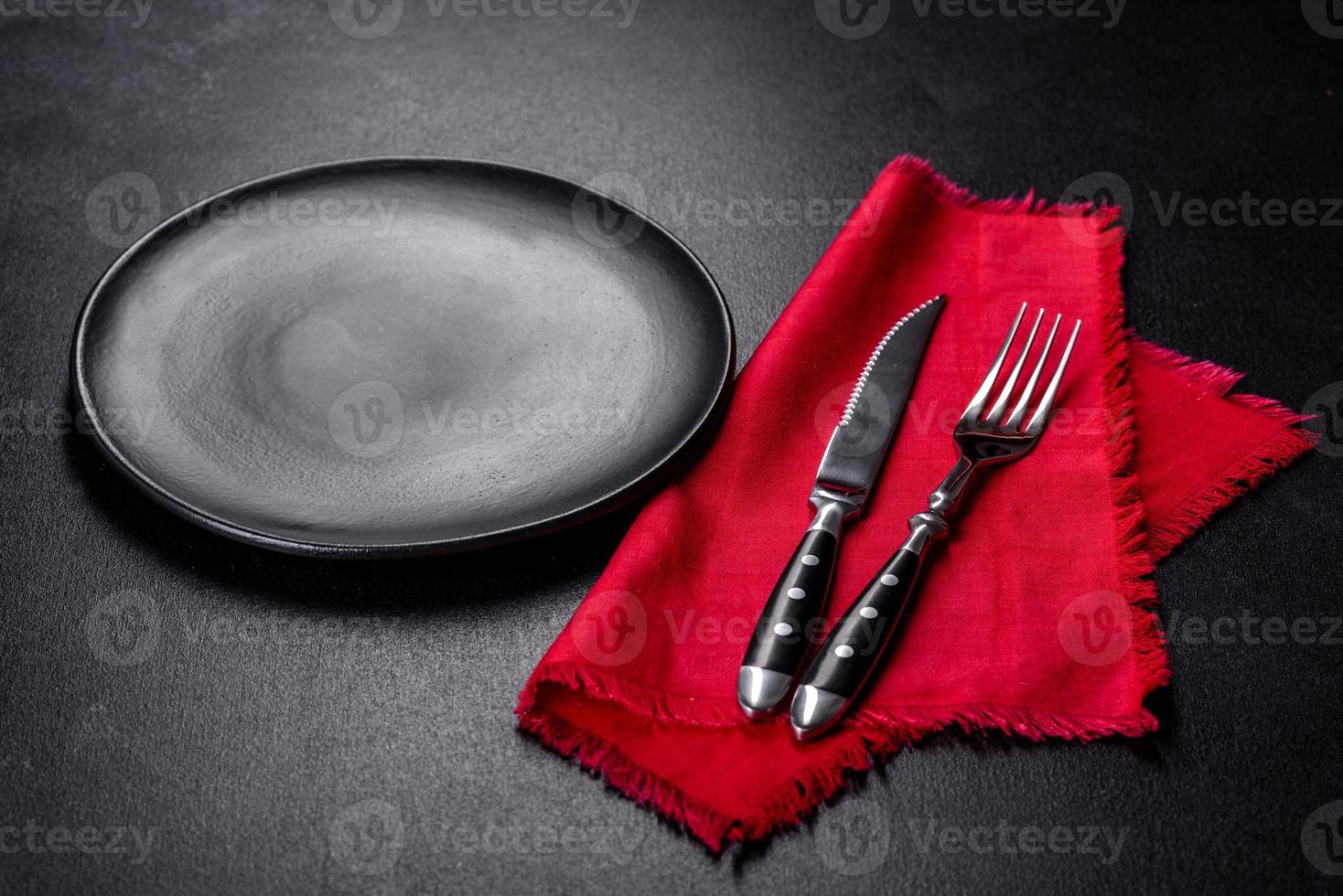 Christmas table setting with empty black ceramic plate, fir tree and black accessories photo