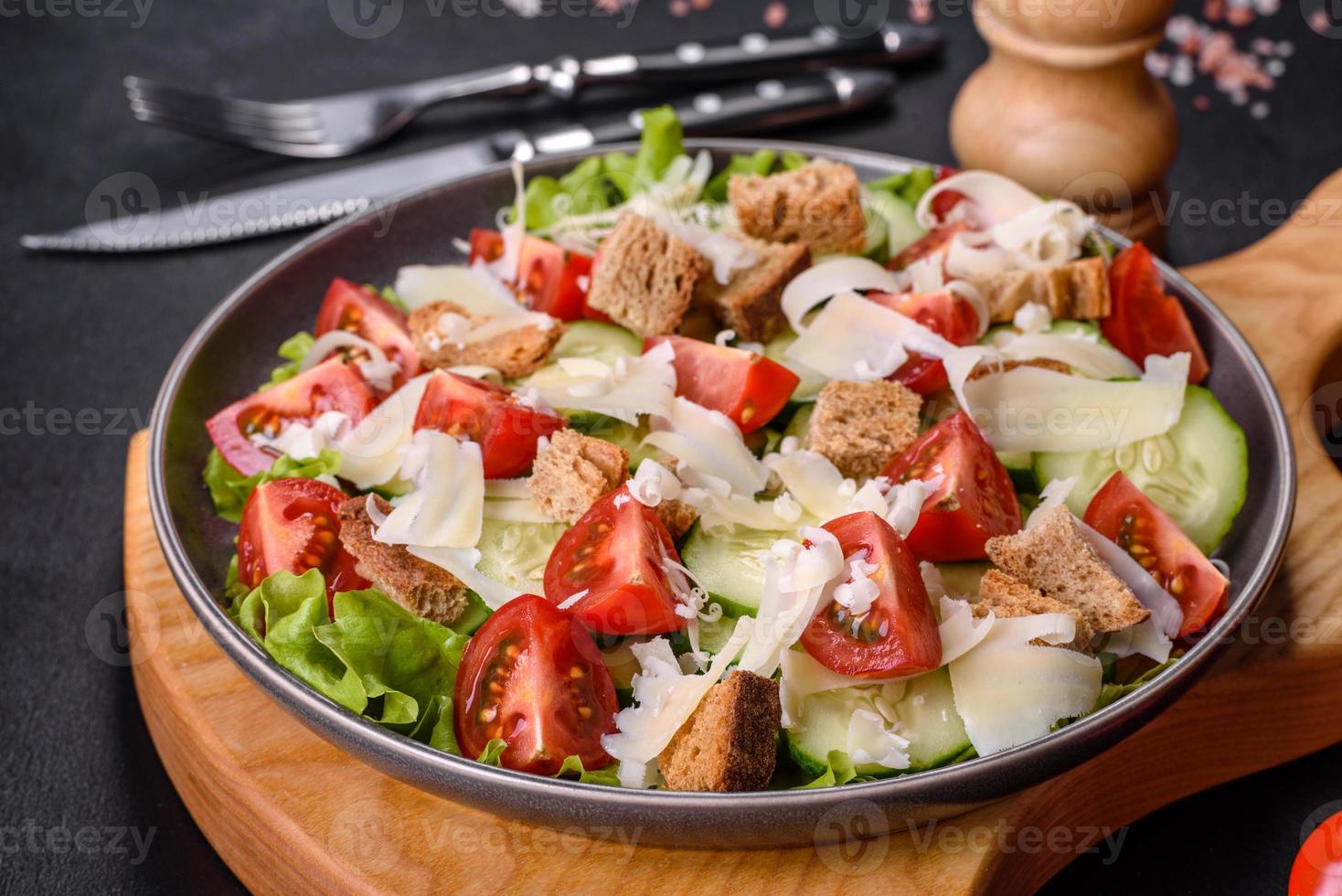 deliciosa ensalada de verduras frescas de primavera con tomates cherry, pepino, pan rallado y queso parmesano foto