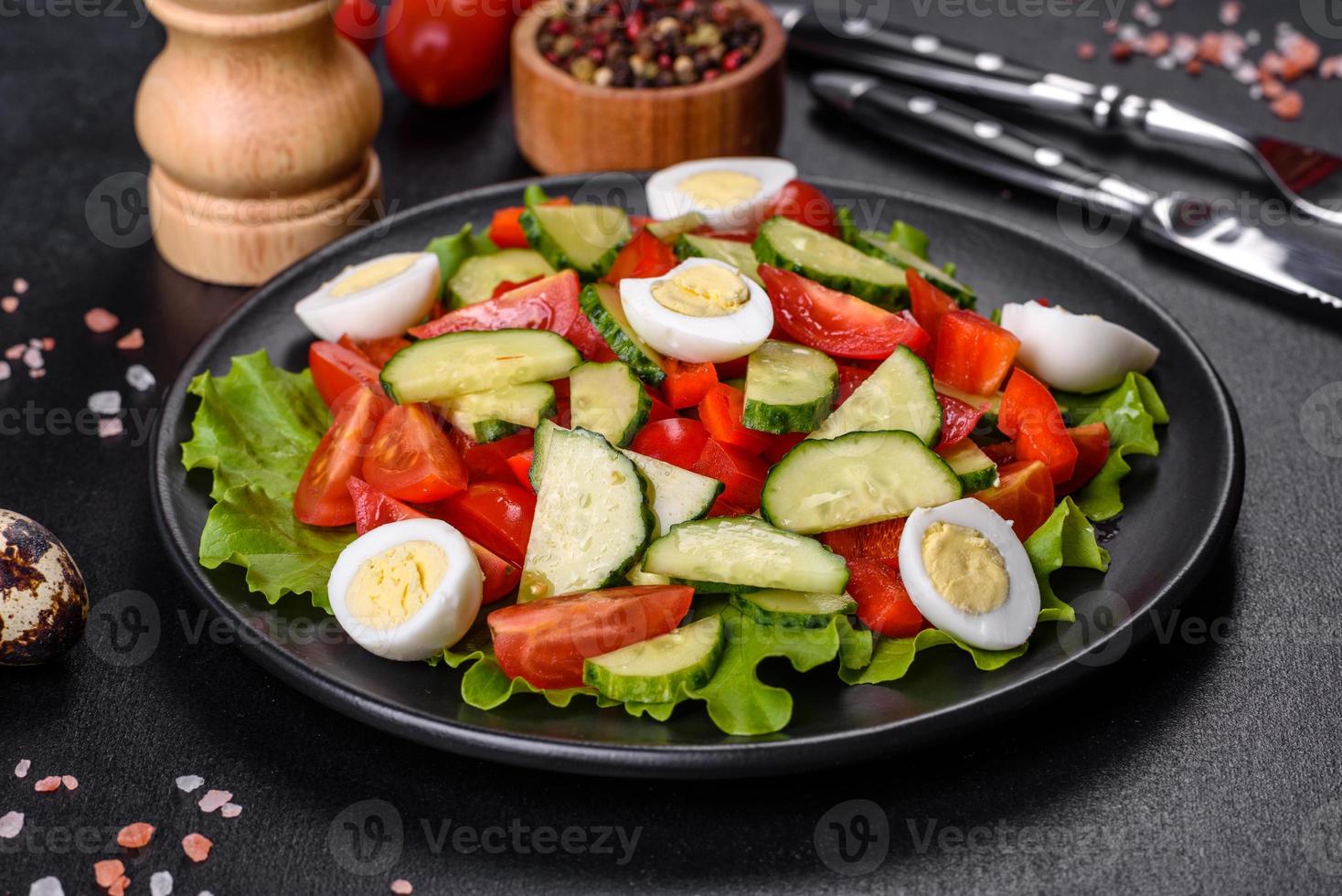 Ensalada de lechuga, pepino, espinacas, tomate y huevos de codorniz con hierbas y limón foto