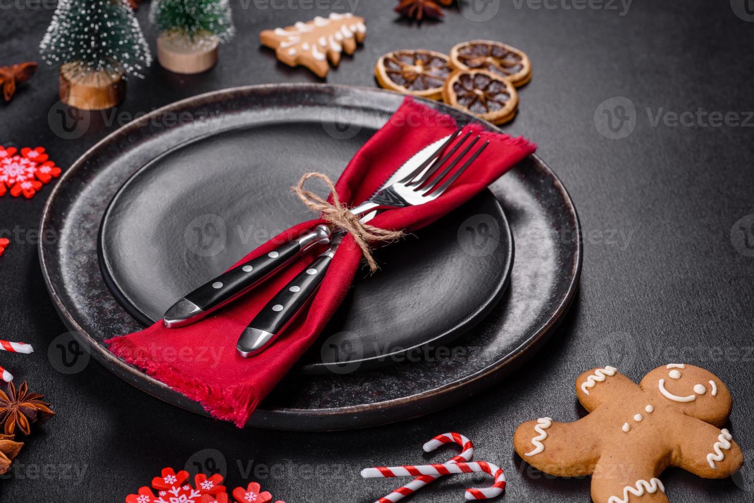 Christmas table setting with empty black ceramic plate, fir tree and black accessories photo