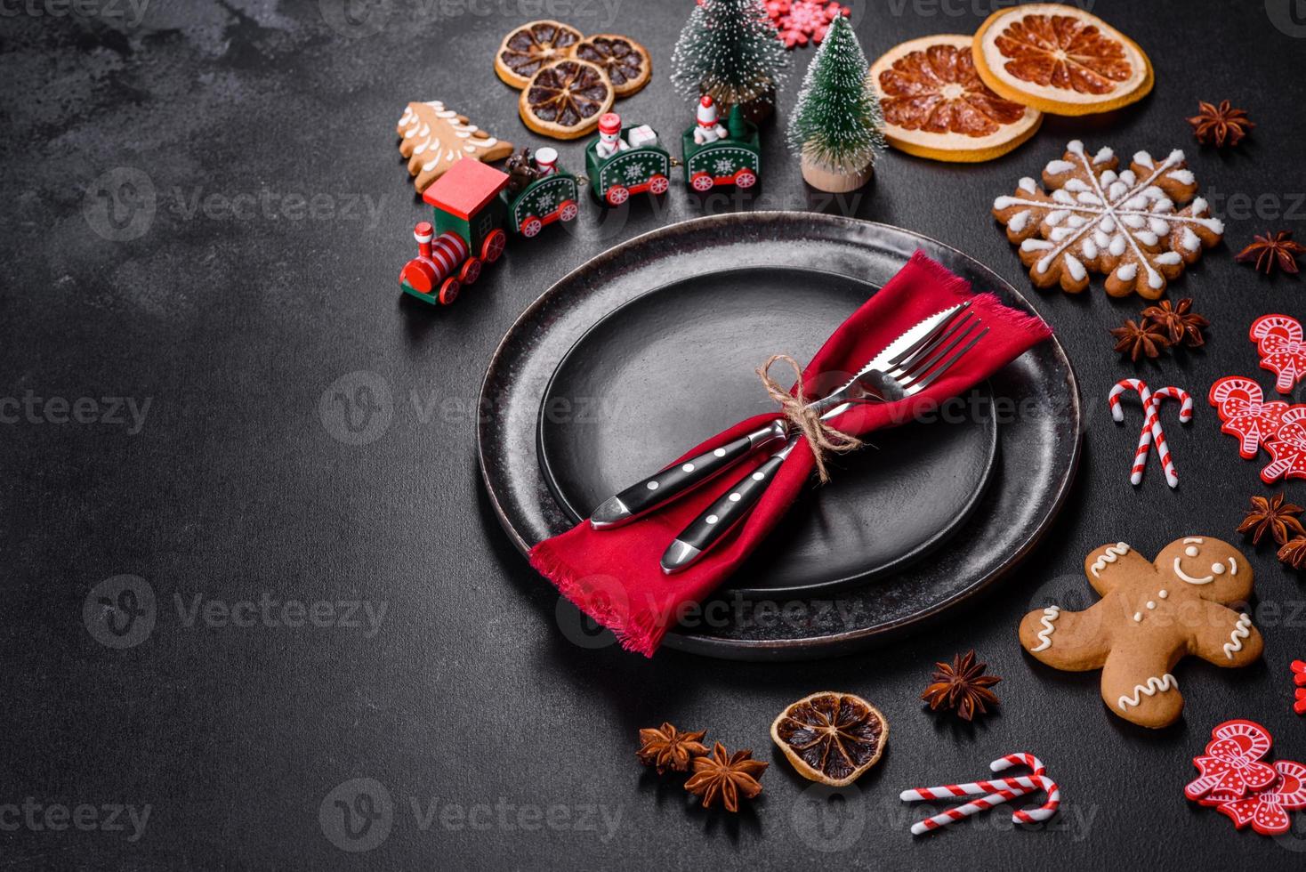 Christmas table setting with empty black ceramic plate, fir tree and black accessories photo