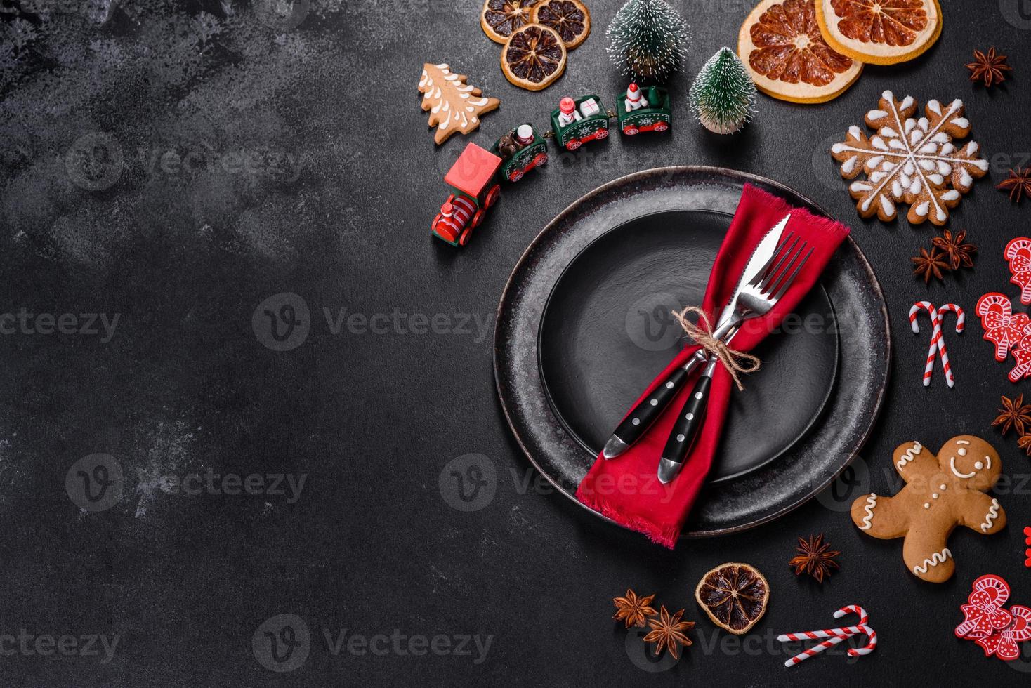Christmas table setting with empty black ceramic plate, fir tree and black accessories photo