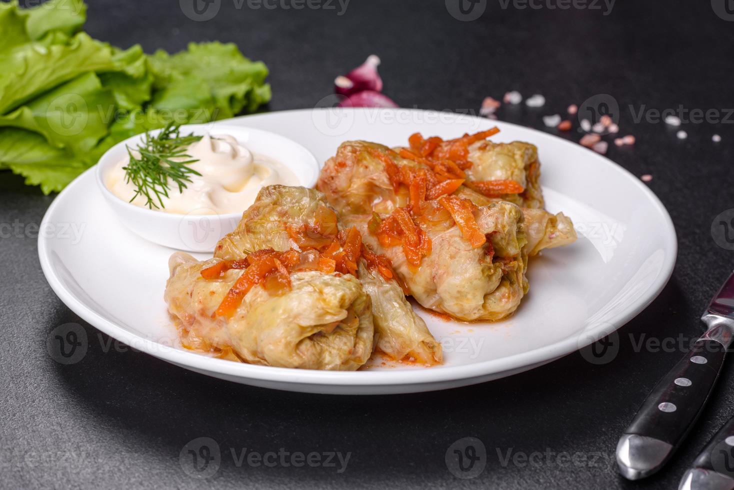 rollos de col rellenos de carne molida y arroz servidos en un plato blanco foto