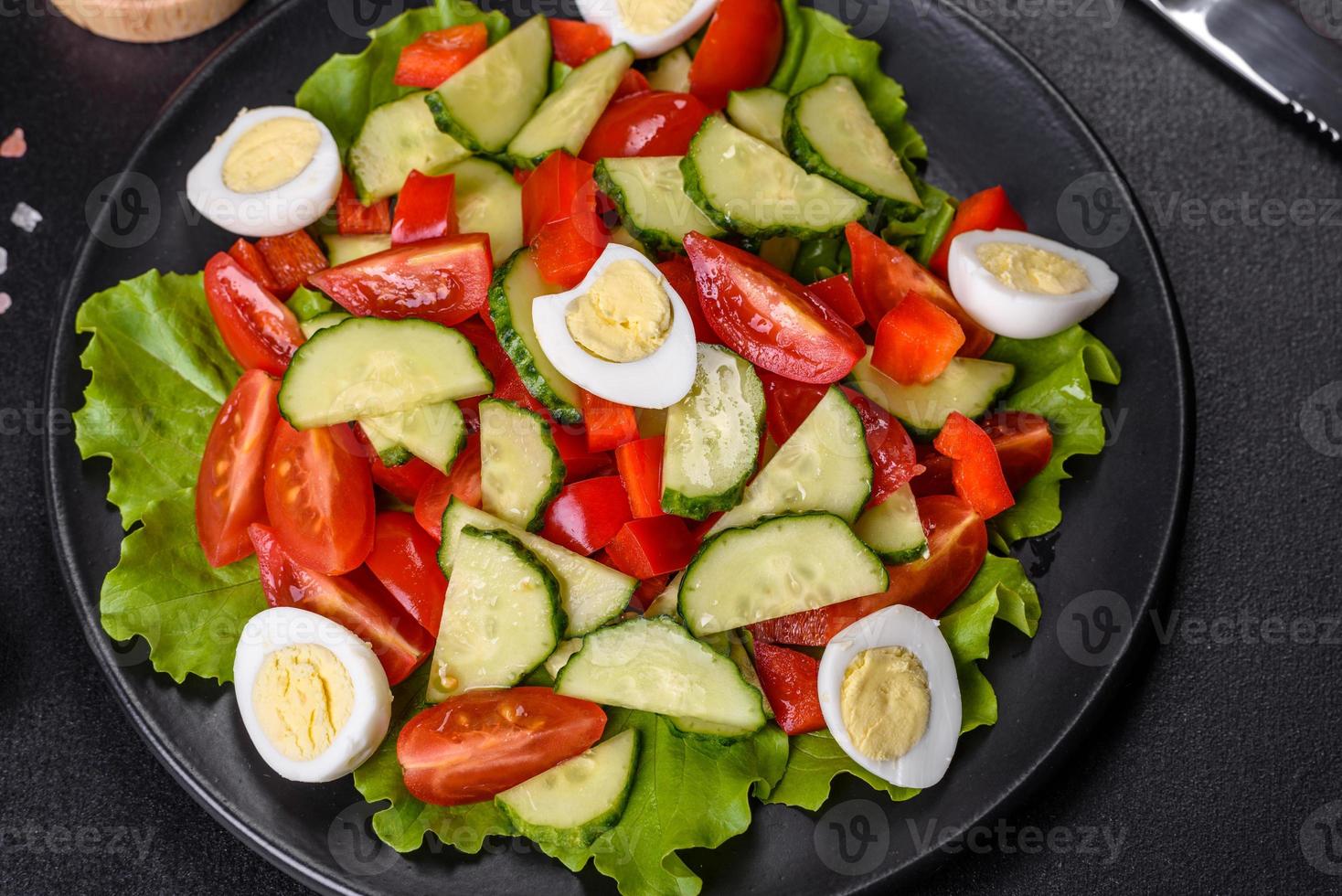 Lettuce, cucumber, spinach, tomato and quail eggs salad with herbs and lemon photo