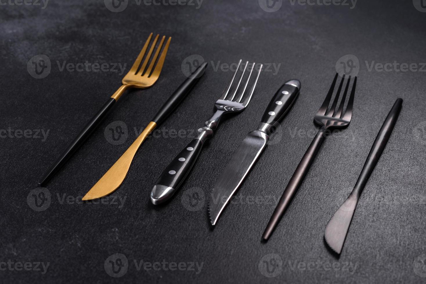 aspecto árbitro taburete varios cuchillos y tenedores en oro negro y plata sobre un fondo de  hormigón oscuro 8002680 Foto de stock en Vecteezy