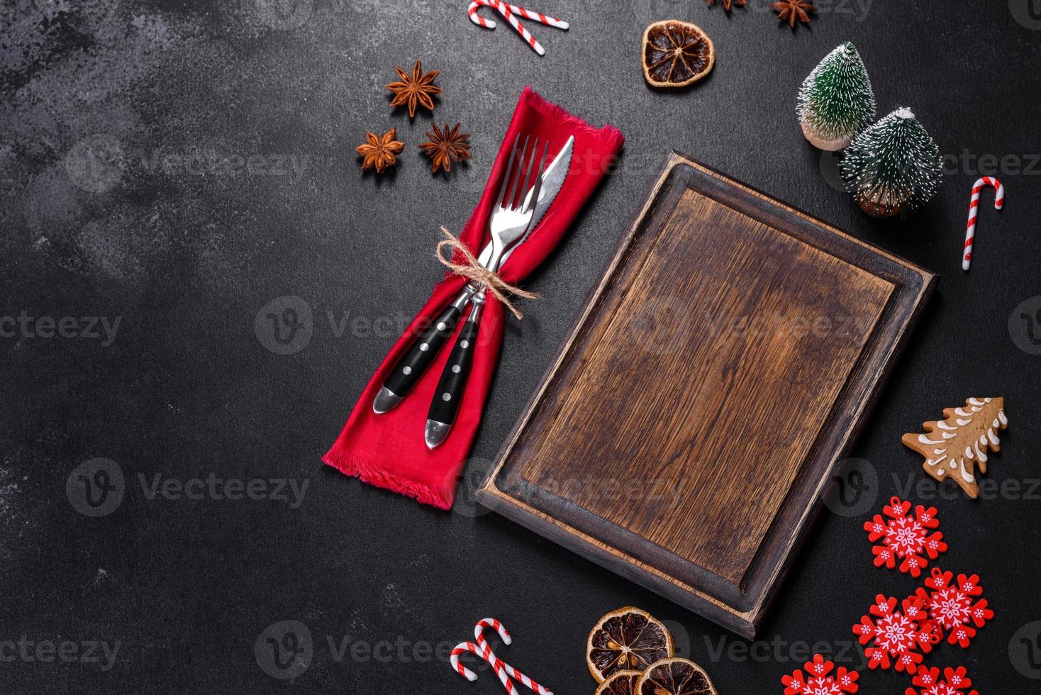 Christmas table setting with empty black ceramic plate, fir tree and black accessories photo