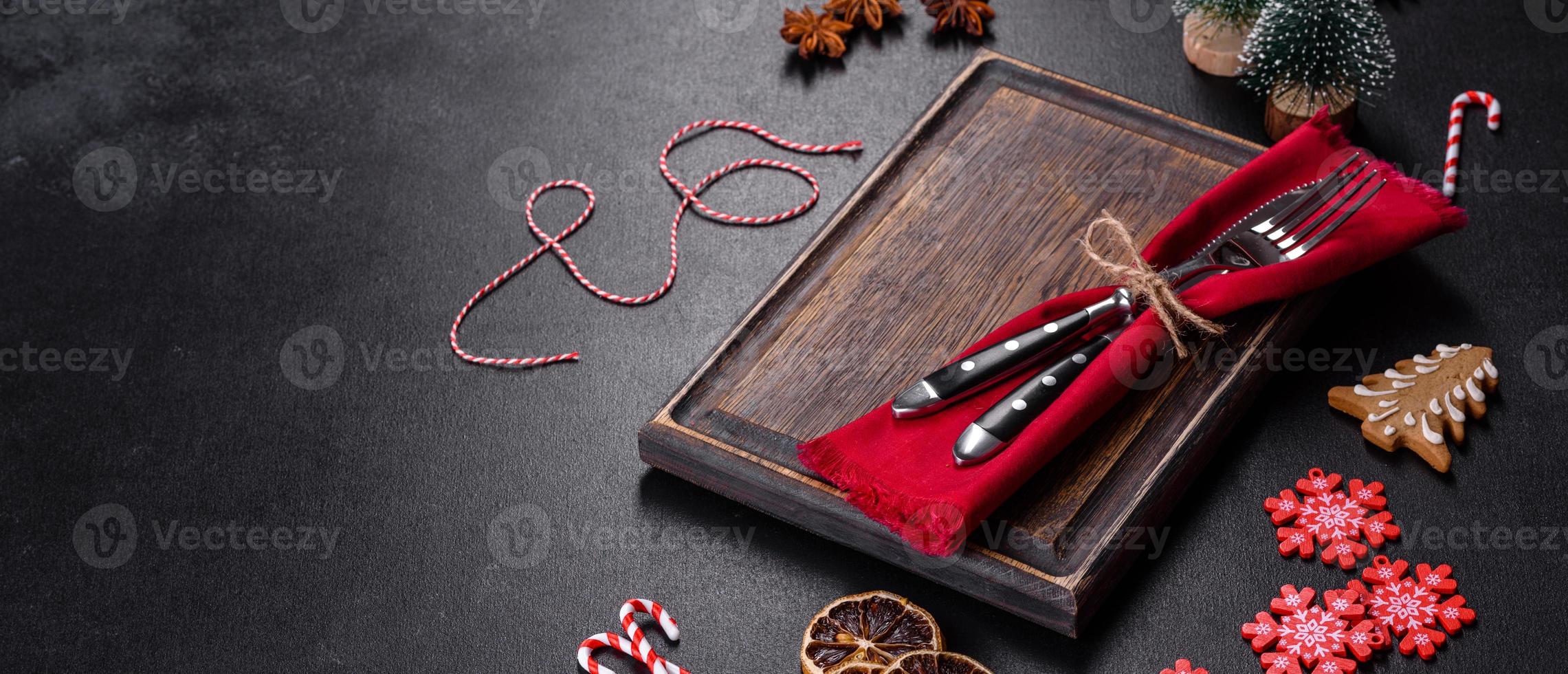 Christmas table setting with empty black ceramic plate, fir tree and black accessories photo